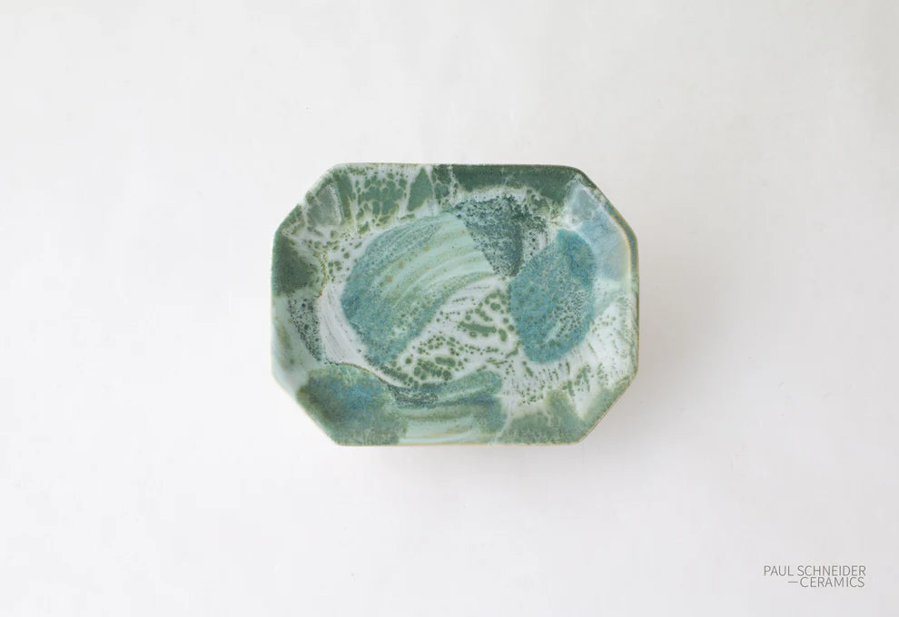Hexagonal ceramic dish with green marbled pattern on a white background