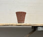 Terracotta pot on a wooden bench against a plain wall