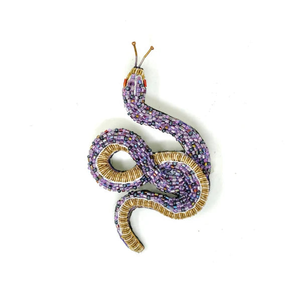 Decorative snake ornament with purple and gold details on a white background