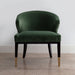 green velvet chair with dark legs and brass accents