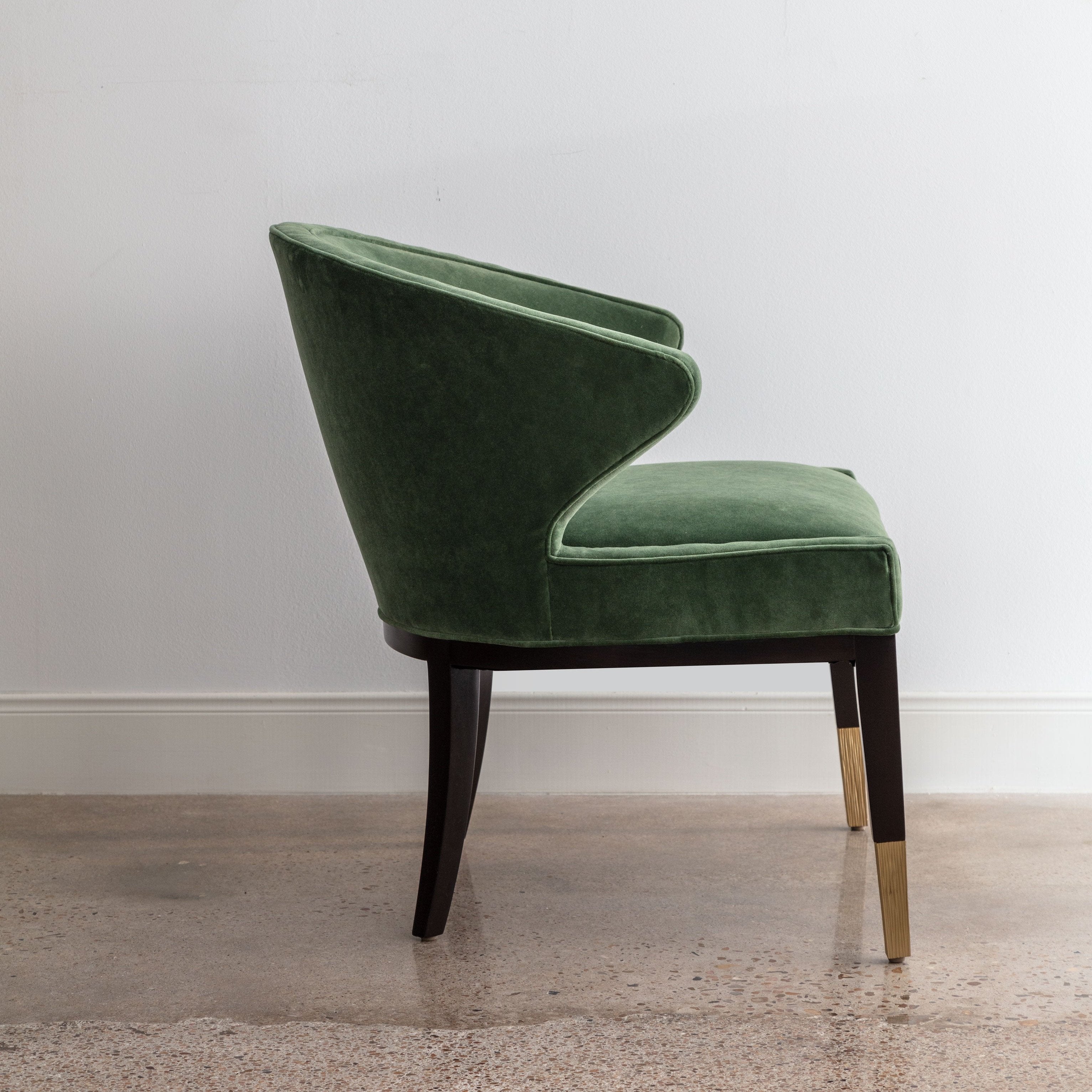 side view of green velvet chair with rounded back