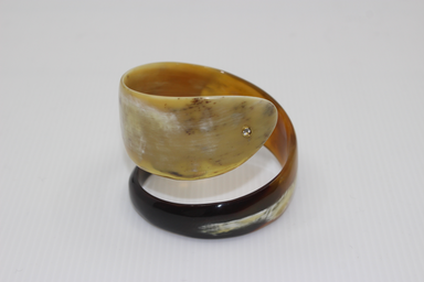 Horn ring with a central diamond on a white background