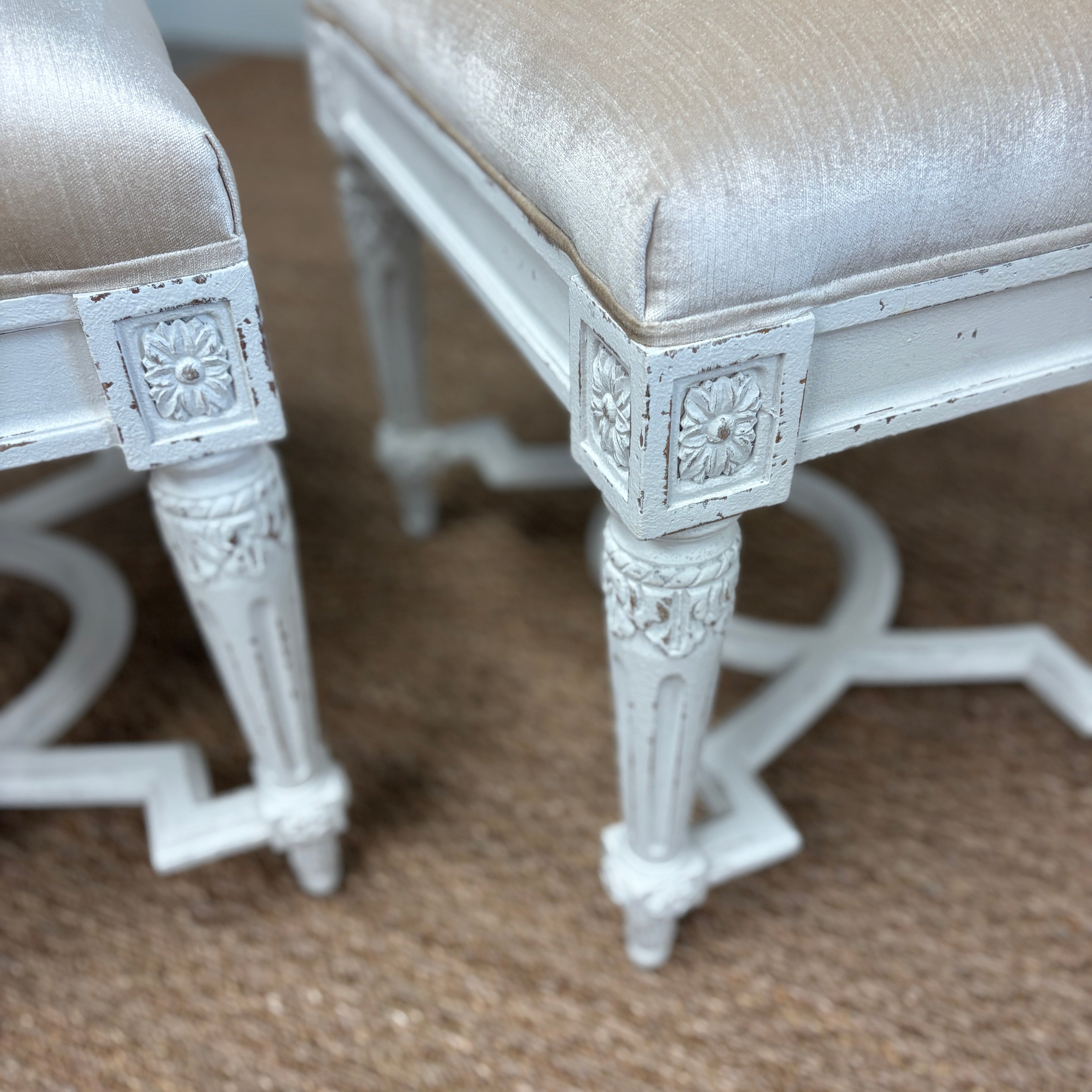 leg, finish, and upholstery detail of two velvet-top stools