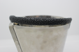 Metallic ice bucket with black textured rim on a light gray background