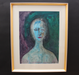 Framed abstract painting of a face with a gold frame on a black background