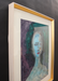Framed artwork with a stylized portrait of a woman on a dark background