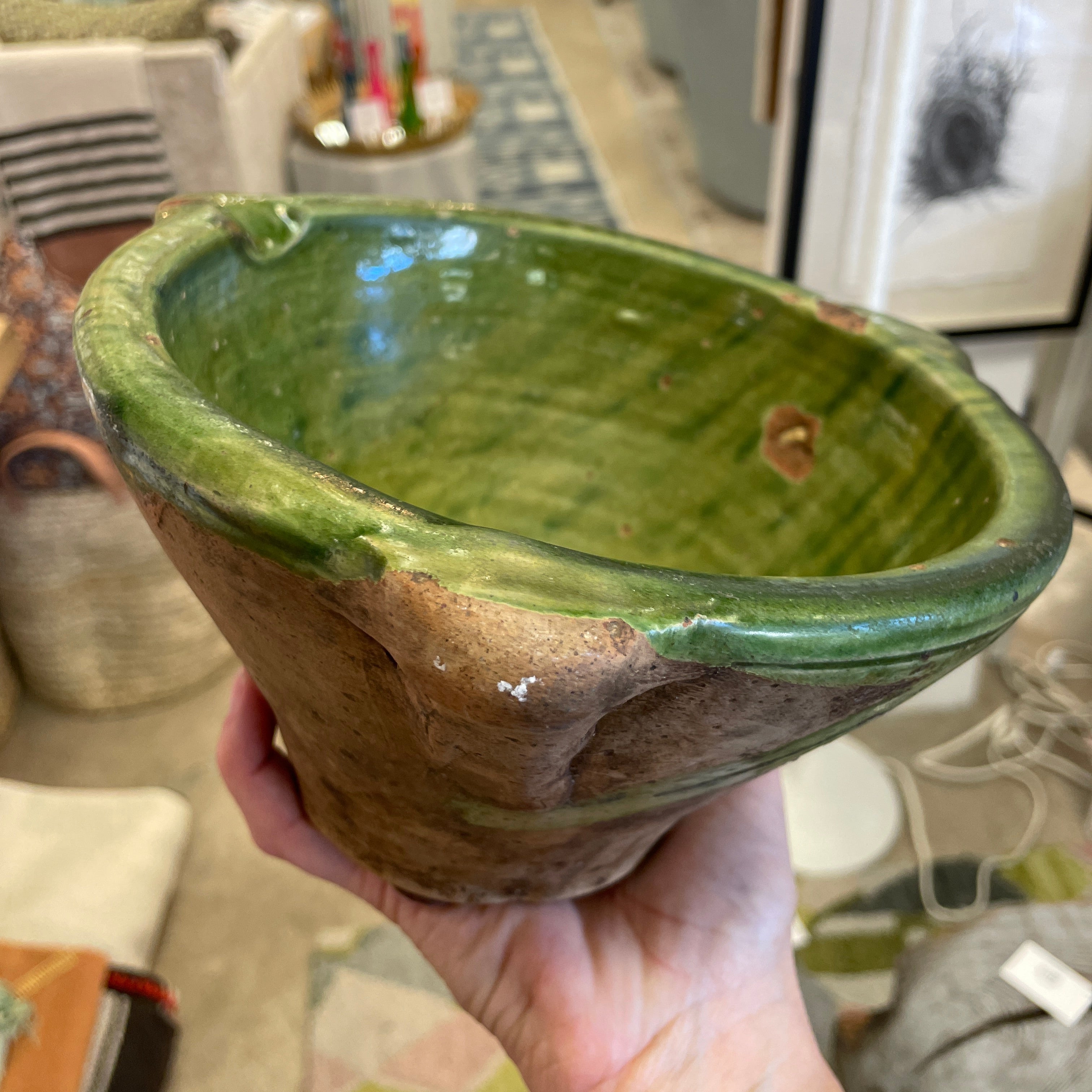 hand holding green glazed pot to show size