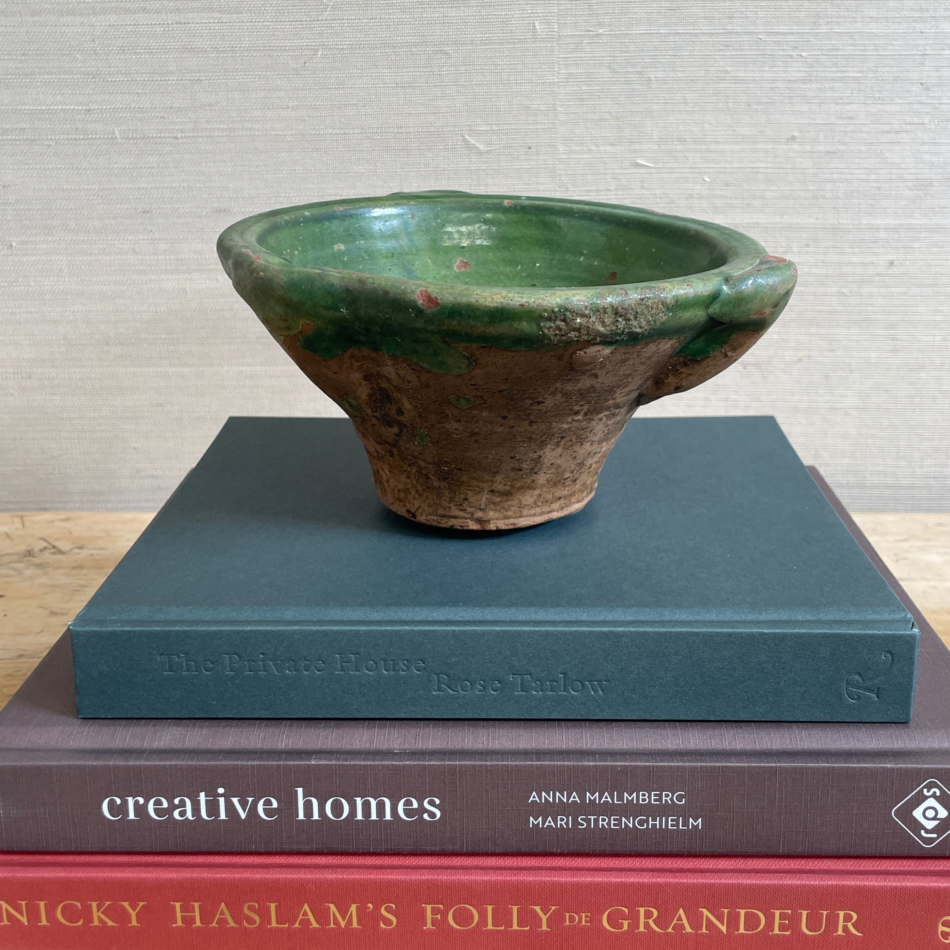 green glazed mortar bowl on stack of books