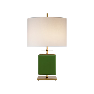 A table lamp with a square green base, a warm brass-toned metal stem and feet, and a large cylindrical off-white fabric drum shade, shown against a plain white background.