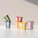 Set of colorful striped ceramic cups on a light surface with a neutral background