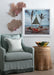 linen slipcovered chair beneath framed photograph and wicker side table, sea fans on wall