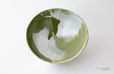 Green ceramic bowl with white interior on a white background