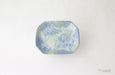 Rectangular ceramic dish with blue and green speckled pattern on a white background