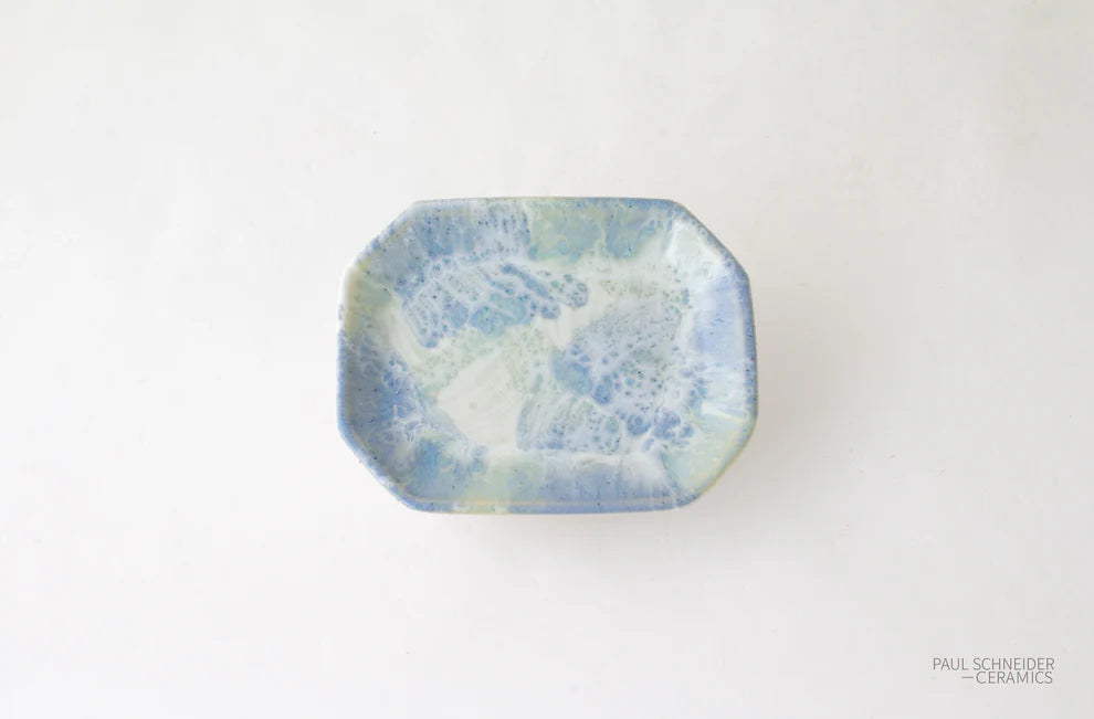 Rectangular ceramic dish with blue and green speckled pattern on a white background