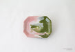 Hexagonal ceramic dish with pink and green marbled pattern on a white background