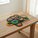 Set of colorful woven coasters on a wooden table
