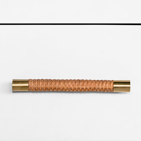 Cabinet handle with woven design and gold accents on a white background