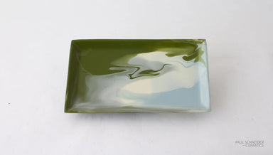 Rectangular ceramic dish with green and white marbled design on a white background