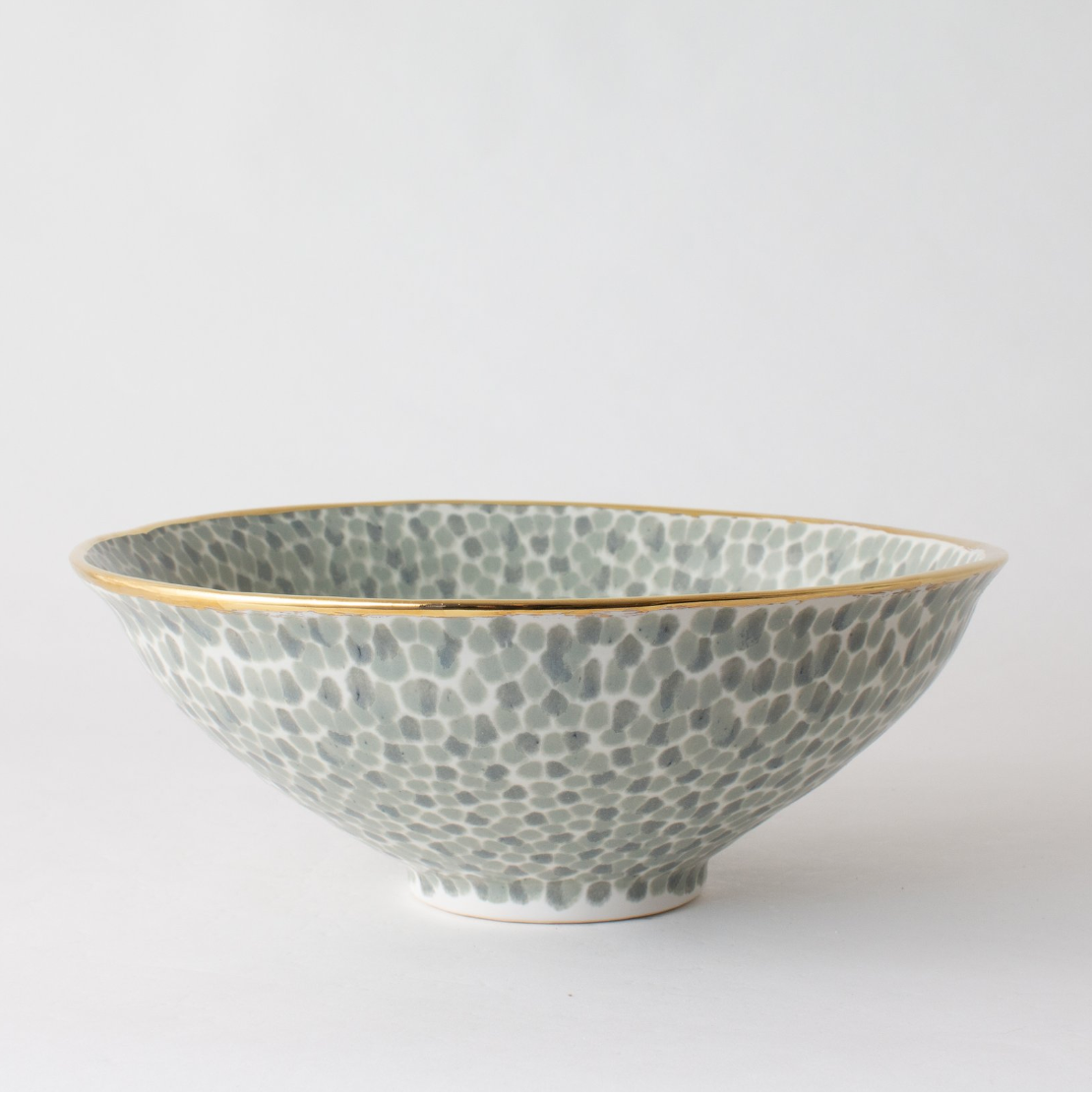 dappled ceramic bowl in pale green with gold edge