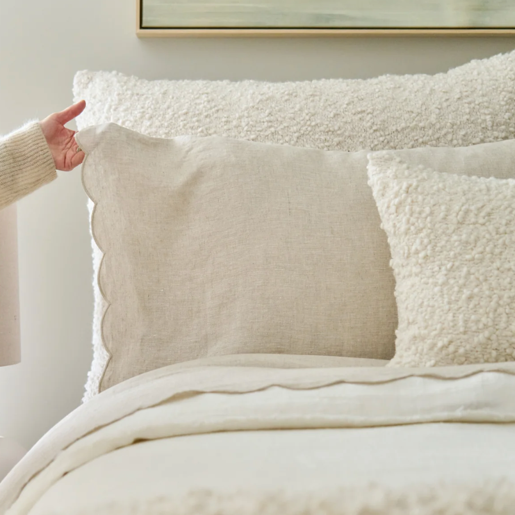 showing scallop edge of flax linen pillowcase on bed