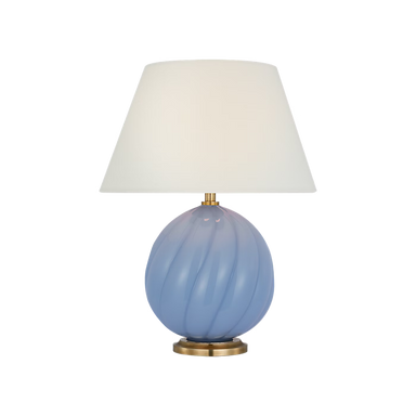 Table lamp with a blue glass base and white lampshade on a black background