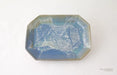 An octagonal ceramic dish with a textured, marbled glaze in shades of blue, teal, and white, set against a plain white background.