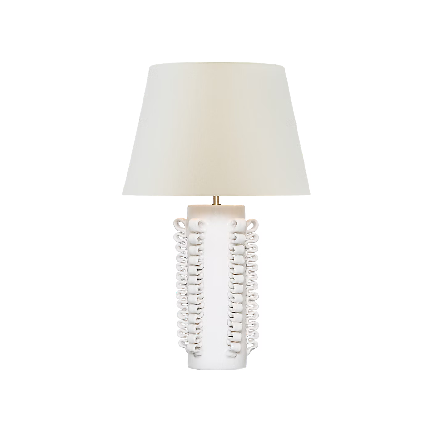 A table lamp with a tapered off-white fabric shade and a sculptural white ceramic base featuring vertical loops and a small gold-toned accent at the top, shown on a plain white background.