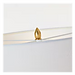 A close-up of a small gold teardrop-shaped crystal or gemstone resting on a clear curved glass surface against a white background.