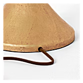 Close-up of a lamp cord threaded into the base of a bell-shaped lamp base shown against a plain white background.