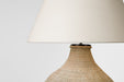 Lamp with woven base and beige lampshade on a white background
