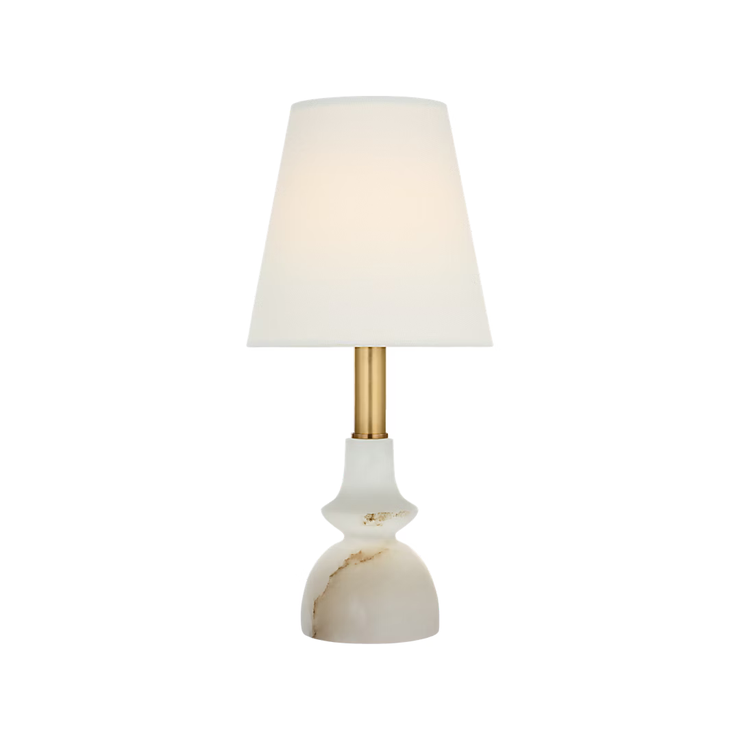 A modern table lamp with a white tapered fabric shade, a brushed gold metal stem, and a white onyx marble base with subtle gold veining, shown against a solid white background.