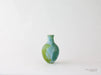 Green and blue ceramic vase on a white background