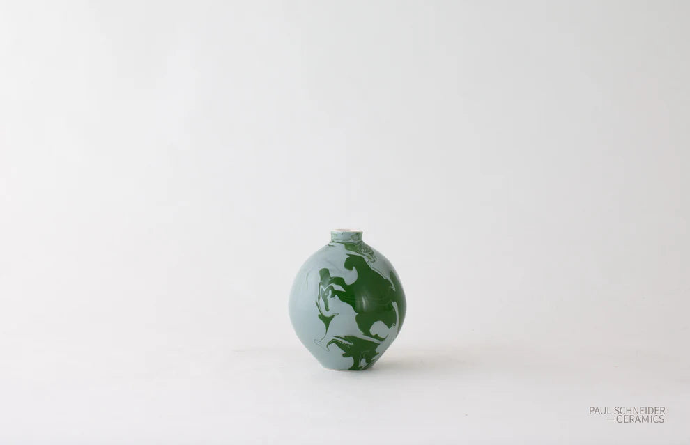 Small ceramic vase with green design on a white background