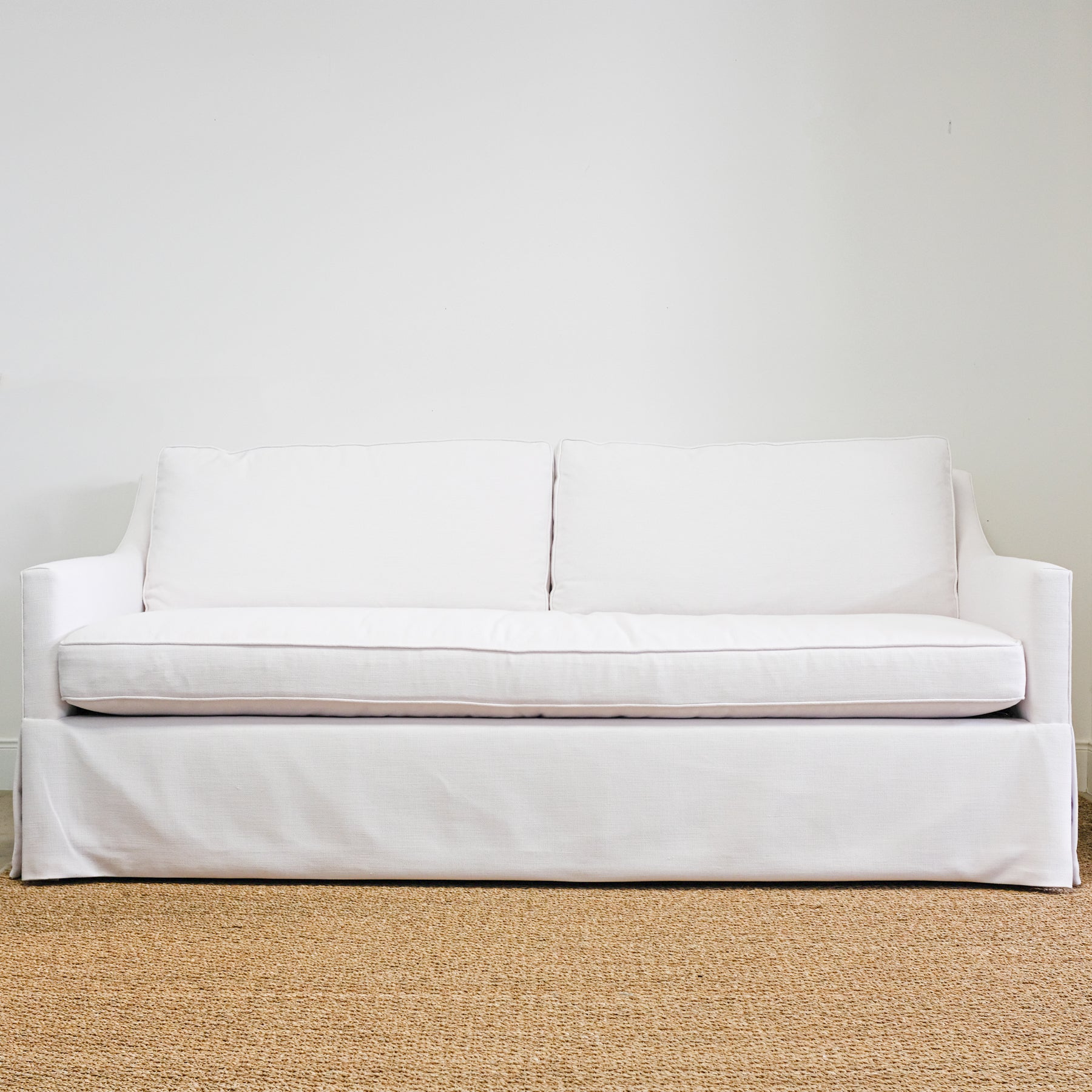 white sofa with bench seat and two loose back cushions