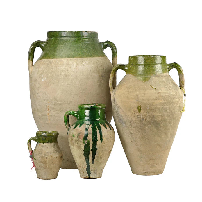 Four ceramic vases with green accents on a white background