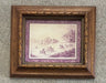 A framed art print featuring a vintage illustration of horse racing, set in an ornate brown wooden frame with a purple mat border, displayed against a textured gray concrete wall.