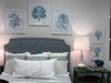 Bedroom with a bed featuring striped pillows, framed artwork on the wall, and a lamp on a nightstand.