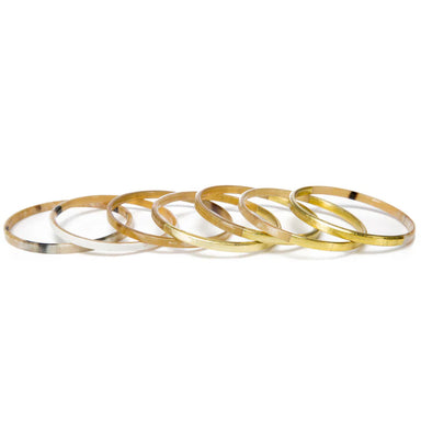 Set of gold bangles on a white background