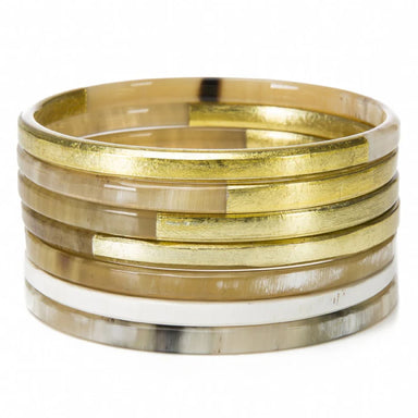 Stack of gold and silver bangles on a white background