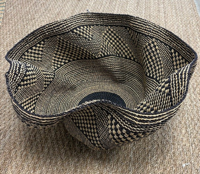 Woven basket with a geometric pattern on a beige surface