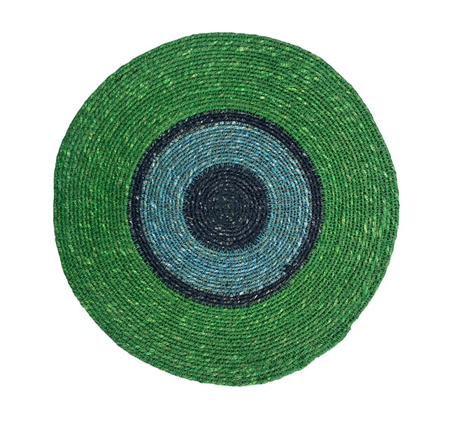 Round green woven mat with concentric color pattern on a white background