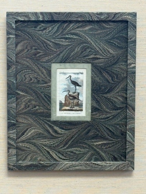 Framed artwork with a wavy pattern on a textured surface