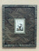Decorative frame with wavy pattern containing a smaller framed picture of birds on a wooden surface.