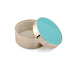 Round container with gold base and turquoise lid on a white background