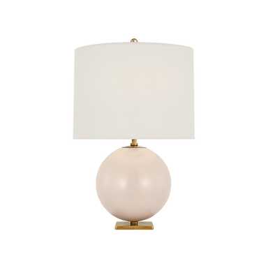 Table lamp with a round pink base and white shade on a black background