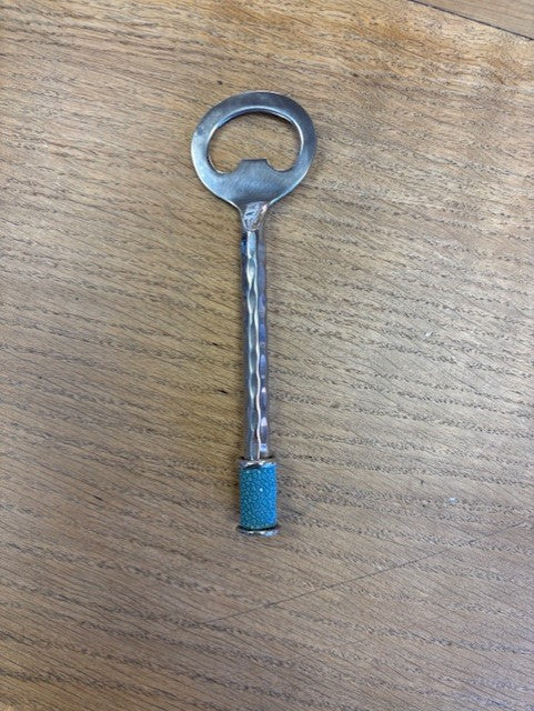 steel bottle opener with a blue tip on a wooden surface