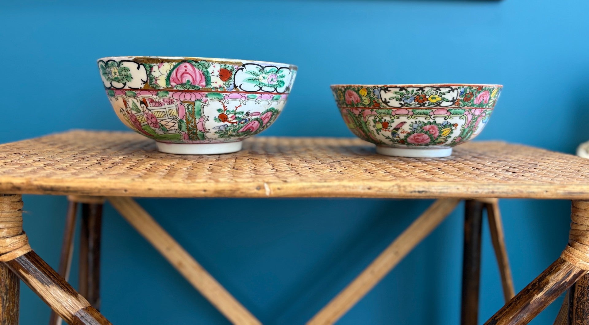 Two decorative bowls on a wooden table against a blue wall