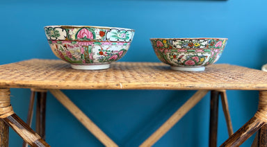 Two decorative bowls on a wooden table against a blue wall