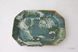 Decorative ceramic tray with a marbled green and blue design on a white background