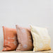 line up of three square moroccan pillows in orange, terra cotta and yellow